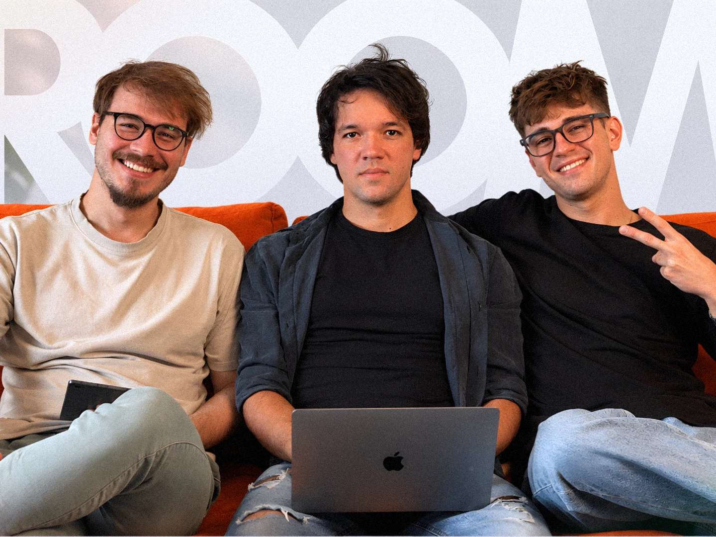 Petar, Marko and Đorđe, the ROOM 211 team, on the orange sofa in the studio