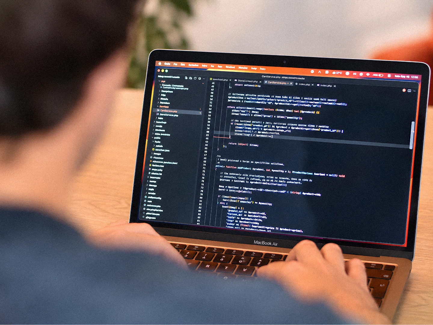 Writing code on a laptop at the ROOM 211 desk