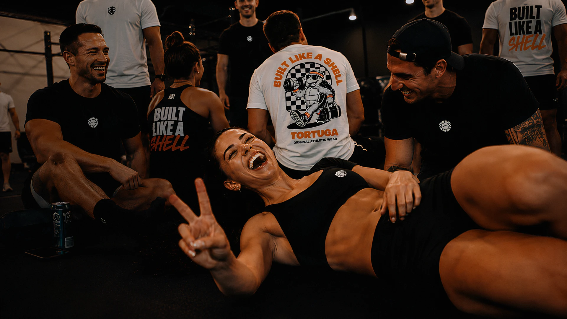 Tortuga members laughing together in the gym, in the merch